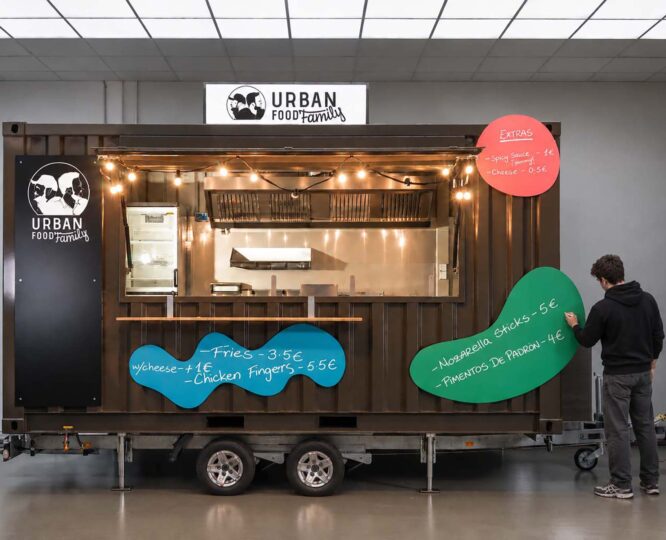 Schwarzer walkingboxes Foodtrailer mit geöffneter Verkaufsklappe, farbigen Designelementen.