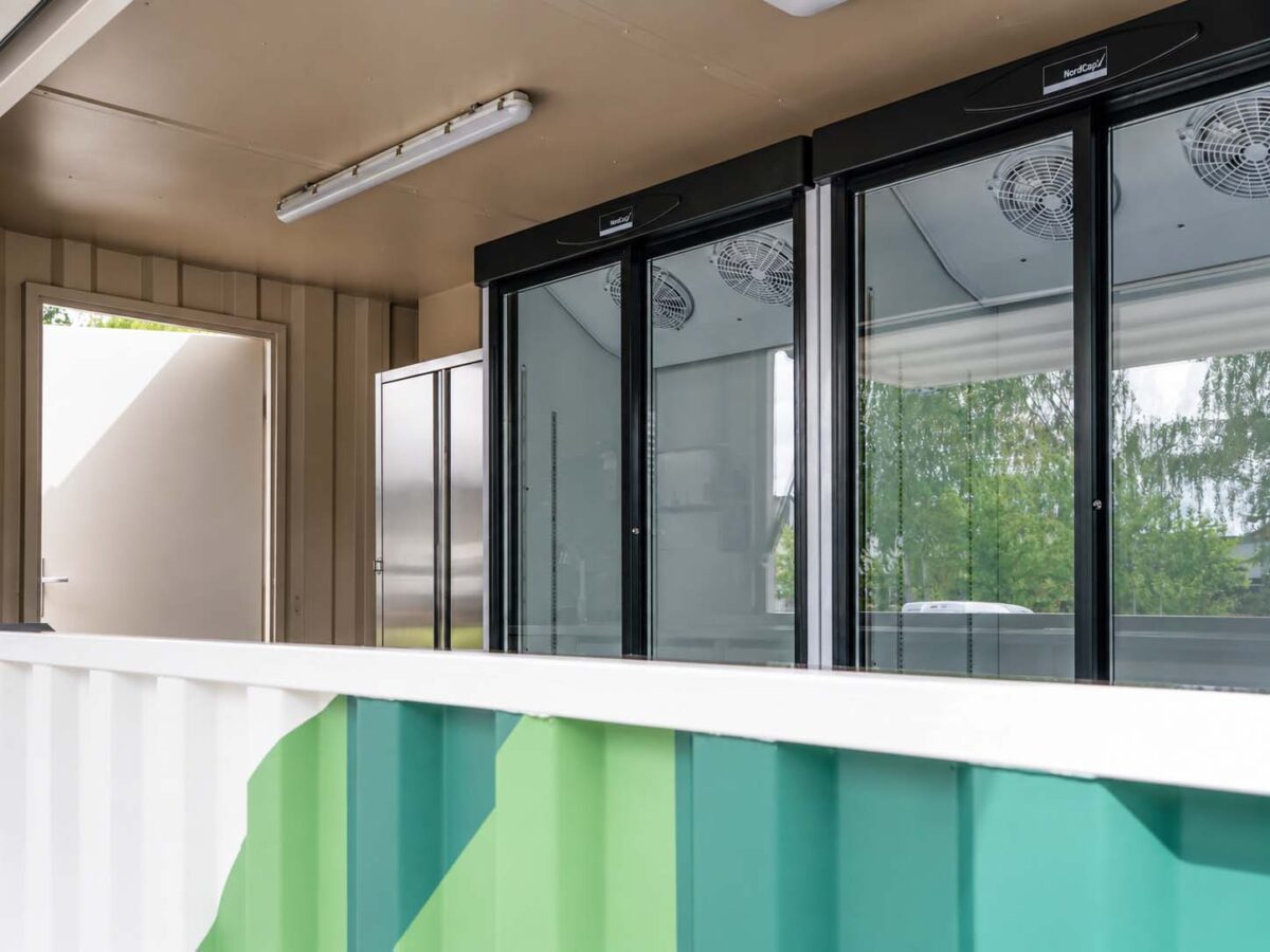 walkingboxes-foodtrailer_tinyfish_DSC03666_cg Innenraum des Tinyfish Foodtrailers mit großen gekühlten Glasvitrinen für Sushi und maßgefertigtem Edelstahlausbau.